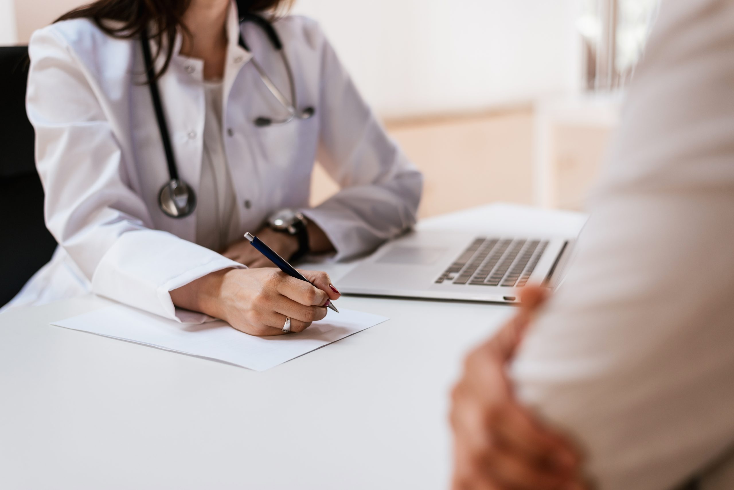 Close up of patient and doctor taking notes