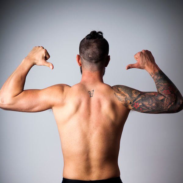 Espalda de hombre con brazo tatuado